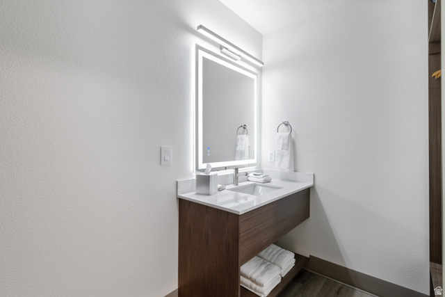 245 Red Cliffs Drive, Unit 104 St. George, UT 84790 - Photo 24 of 33 Bathroom with vanity, a textured wall, and wood finished floors