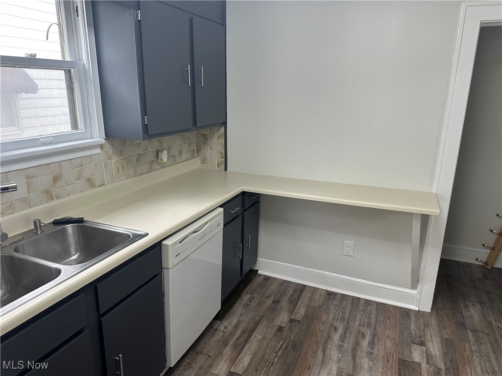 835 Inman Street Akron, OH 44306 - Photo 7 of 25 Kitchen featuring light countertops, white dishwasher, dark wood-style floors, backsplash, and blue cabinetry