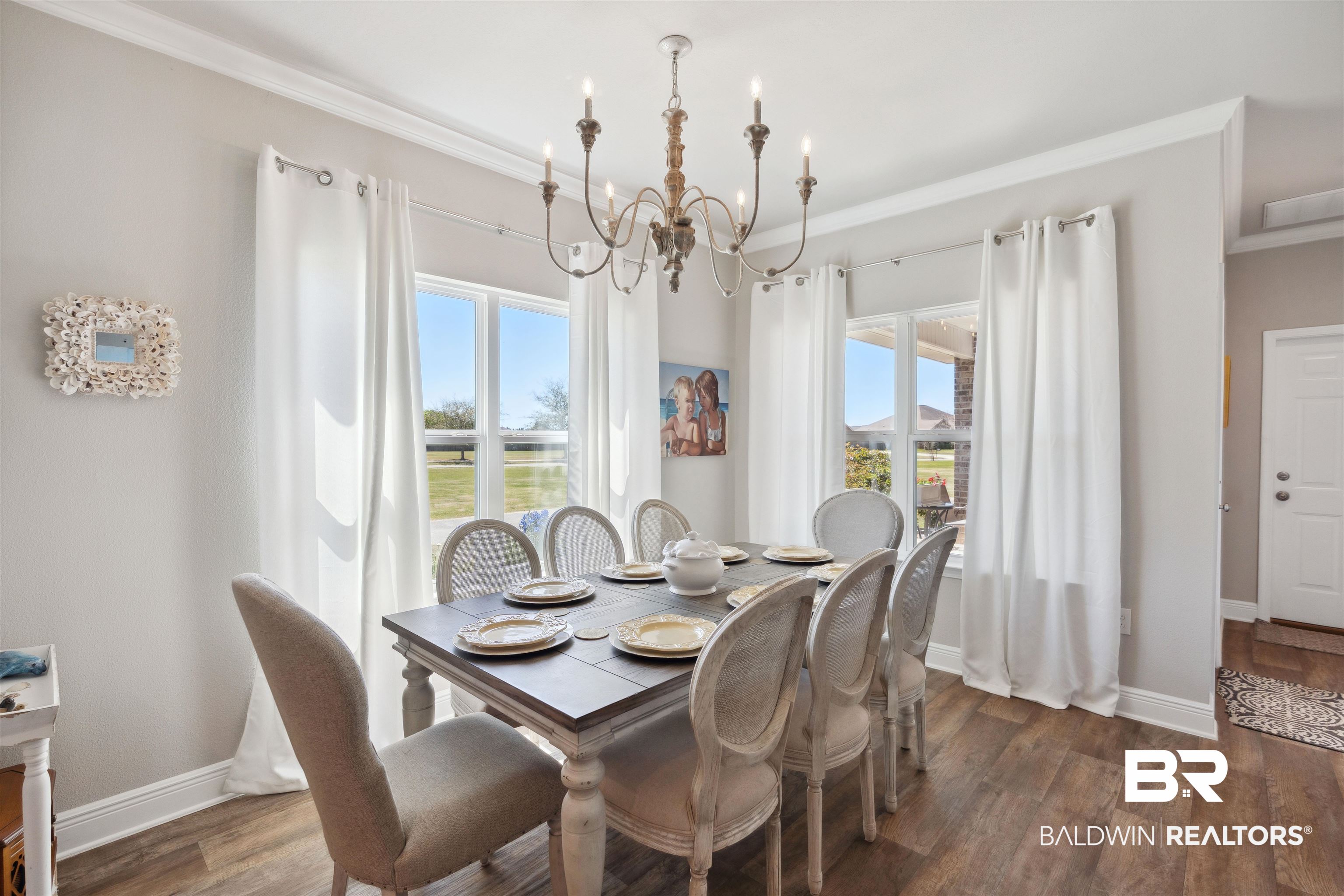 23809 Devonfield Lane Daphne, AL 36526 - Photo 13 of 29 Dining room with dark wood-style floors, an inviting chandelier, ornamental molding, and a wealth of natural light
