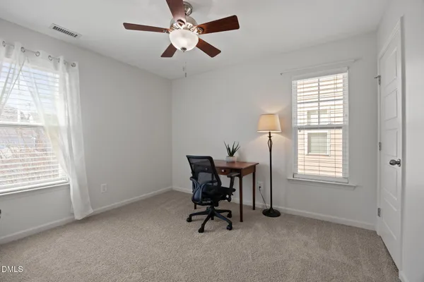 a view of a workspace with furniture and a window