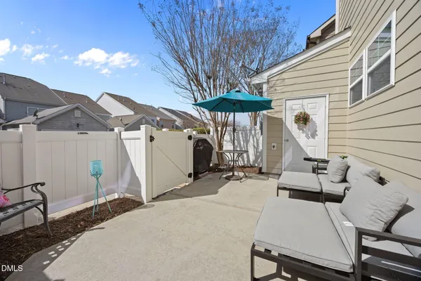 a view of a patio with table and chairs with wooden floor and fence