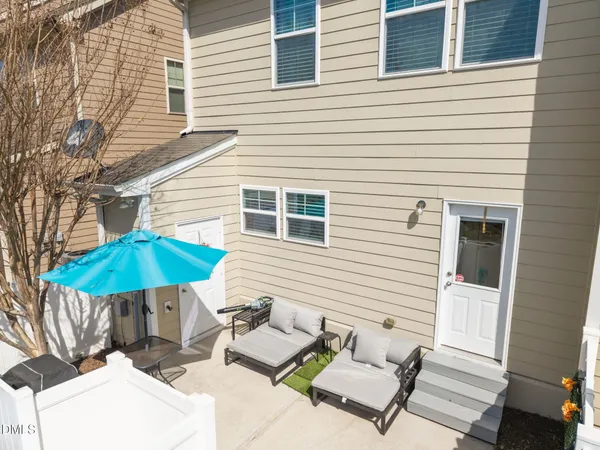 a view of a patio with a table and chairs under an umbrella