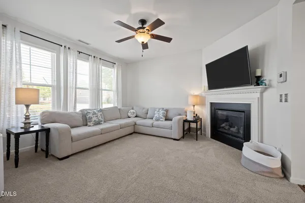 a living room with furniture a fireplace and a flat screen tv