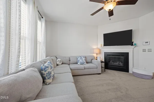 a living room with furniture a fireplace and a flat screen tv