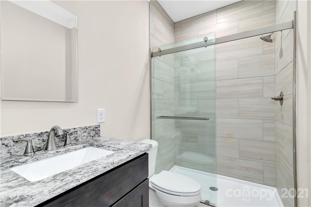357 Ridge View Drive, Unit 4 Clyde, NC 28721 - Photo 15 of 20 a bathroom with a granite countertop sink toilet and shower