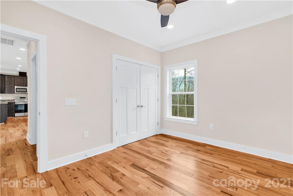 357 Ridge View Drive, Unit 4 Clyde, NC 28721 - Photo 17 of 20 a view of empty room with wooden floor and fan