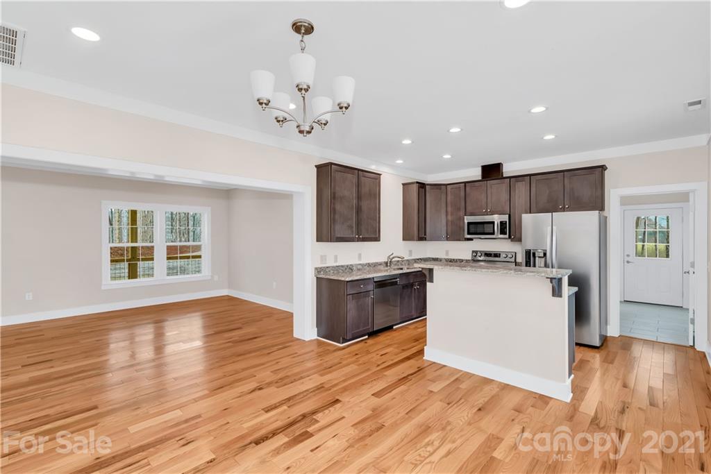 357 Ridge View Drive, Unit 4 Clyde, NC 28721 - Photo 7 of 20 a large kitchen with a center island and wooden floor