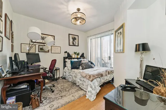 a bedroom with bed a flat tv screen and a bookshelf
