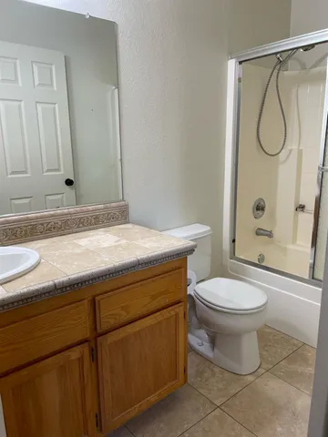 a bathroom with a granite countertop sink toilet and shower