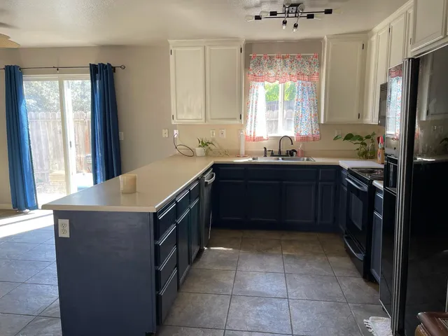 a kitchen with a sink window and cabinets