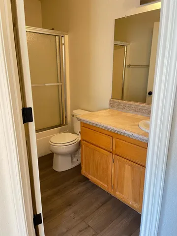a bathroom with a granite countertop sink toilet and shower