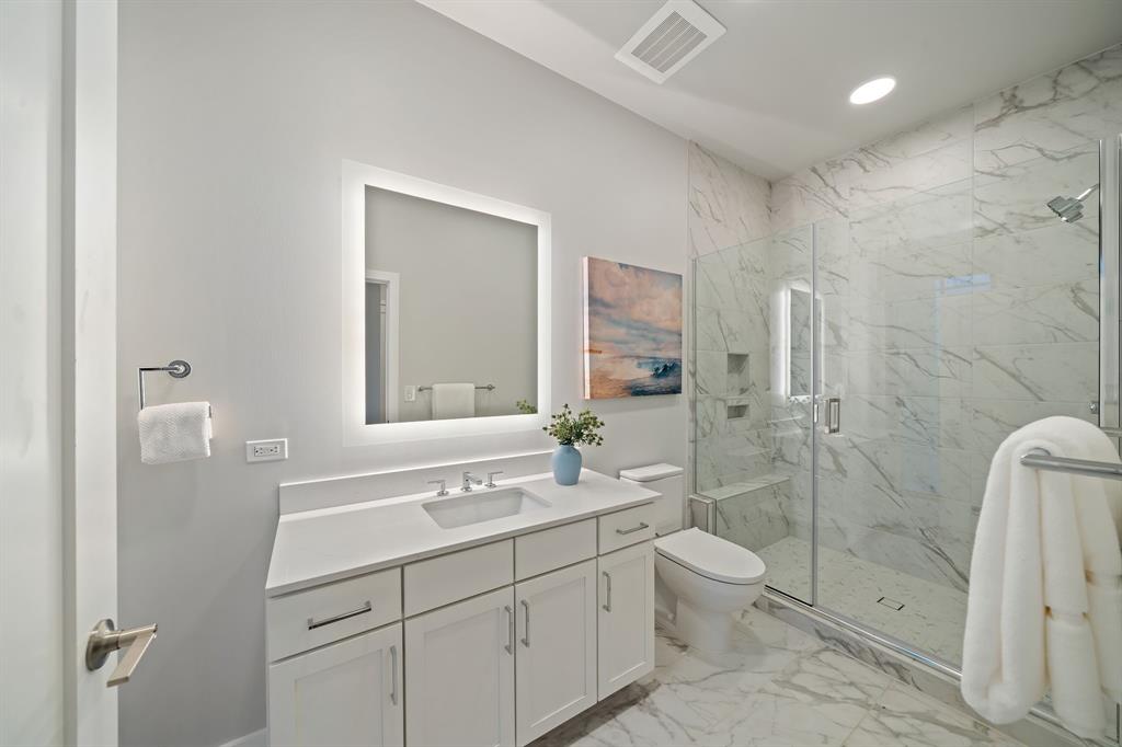3111 Sunset Boulevard, Unit A01 Flower Mound, TX 75022 - Photo 15 of 39 a bathroom with a double vanity sink toilet mirror and shower