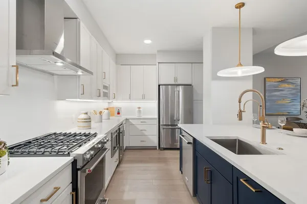 a kitchen with stainless steel appliances granite countertop sink stove and refrigerator