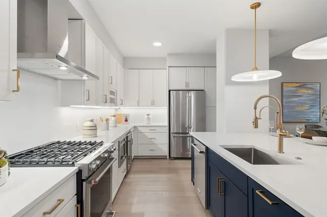 a kitchen with stainless steel appliances granite countertop sink stove and refrigerator