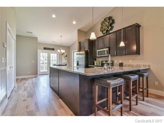 39 Ball Gap Road, Unit 2 Arden, NC 28704 - Photo 4 of 11 a kitchen with stainless steel appliances granite countertop a sink stove and wooden floor