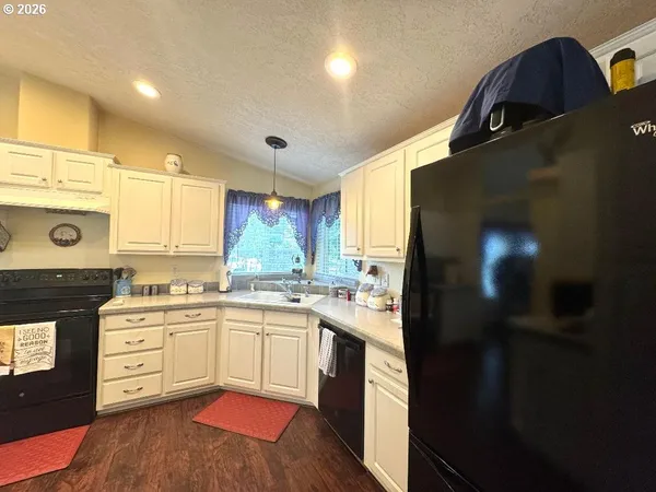 a kitchen with a refrigerator cabinets and wooden floor
