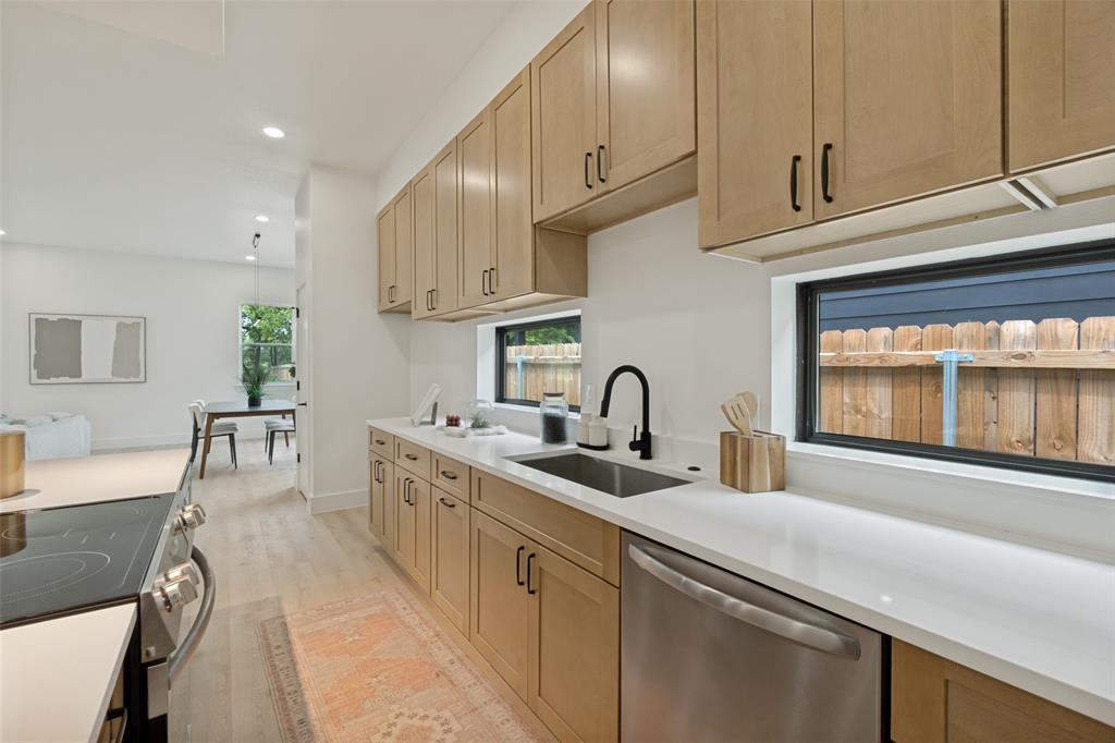 1143 Riverwood Road Dallas, TX 75217 - Photo 11 of 24 Contemporary kitchen featuring light wood-finish cabinetry, white countertops, and stainless steel appliances