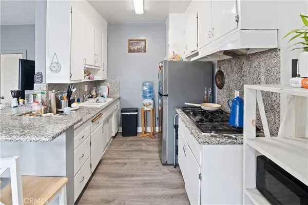 a kitchen with stainless steel appliances granite countertop a sink stove and refrigerator