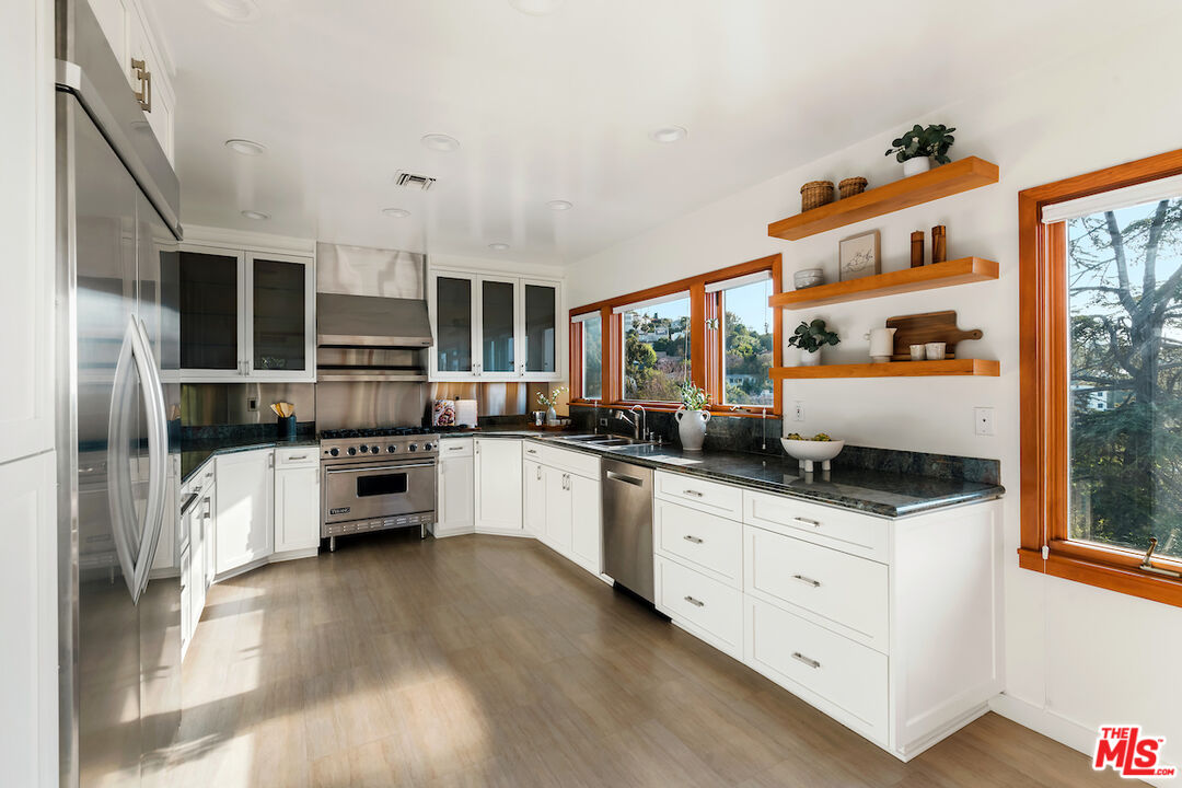 13201 Cheltenham Drive Sherman Oaks, CA 91423 - Photo 15 of 75 a kitchen with stainless steel appliances a stove top oven a sink a refrigerator and cabinets