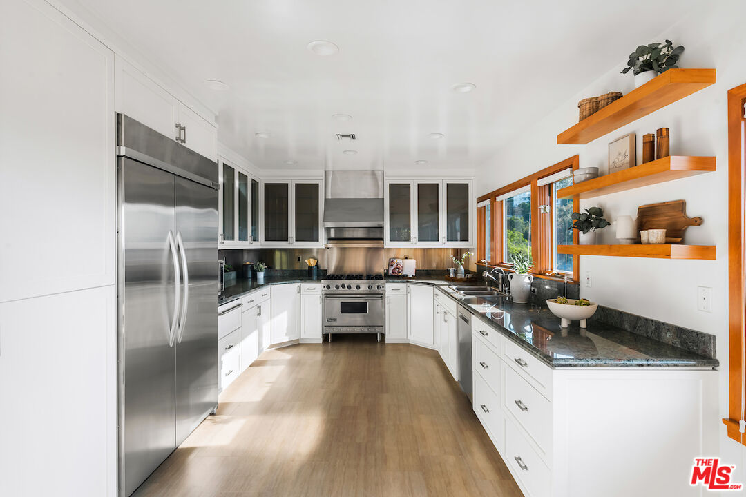 13201 Cheltenham Drive Sherman Oaks, CA 91423 - Photo 16 of 75 a large kitchen with stainless steel appliances kitchen island granite countertop a refrigerator and a stove top oven