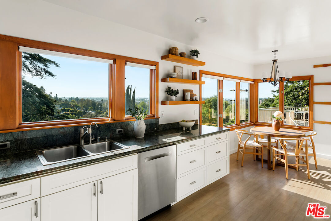 13201 Cheltenham Drive Sherman Oaks, CA 91423 - Photo 17 of 75 a open kitchen with stainless steel appliances granite countertop a sink and white cabinets next to a window