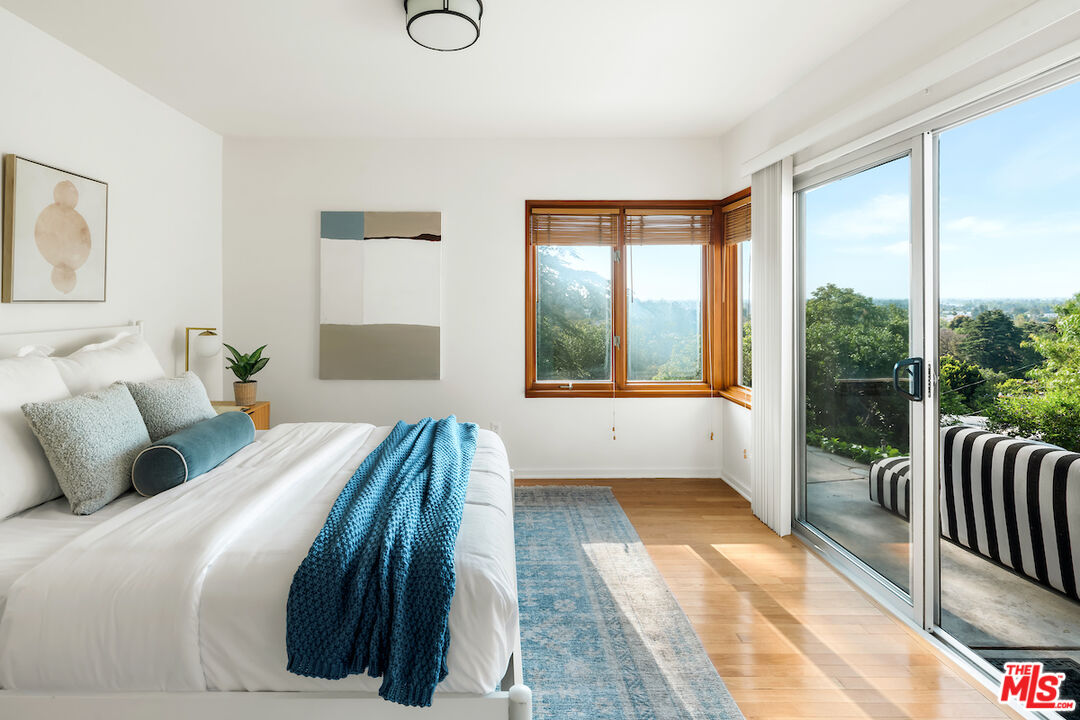 13201 Cheltenham Drive Sherman Oaks, CA 91423 - Photo 32 of 75 a bedroom with a large bed and a large window