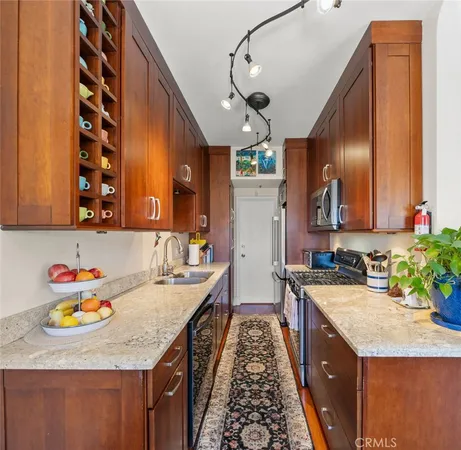 a kitchen with stainless steel appliances granite countertop a sink dishwasher a stove a microwave oven with granite countertops and cabinets