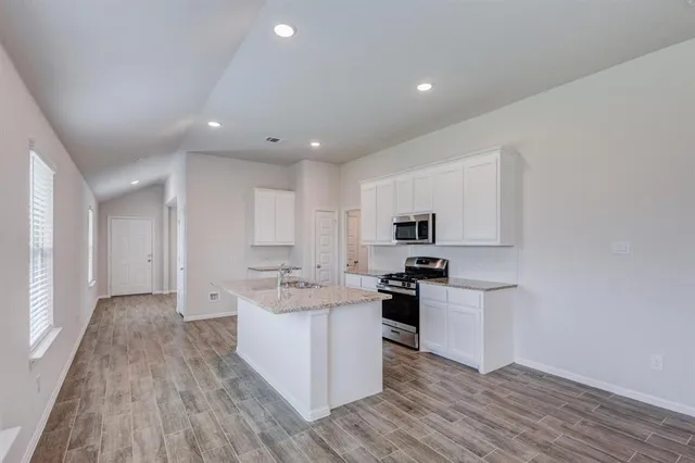 a kitchen with stainless steel appliances a sink stove and cabinets