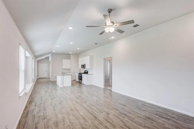 an empty room with windows and fan