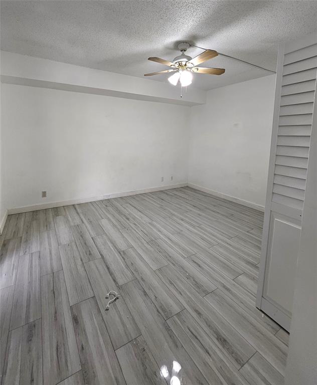 912 Springdale Circle, Unit 912 Palm Springs, FL 33461 - Photo 13 of 15 an empty room with wooden floor and chandelier fan