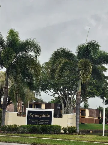 a sign board with tree in the background