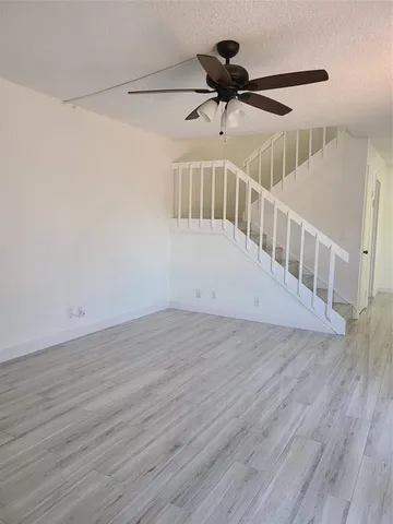 a view of staircase with wooden floor and white walls