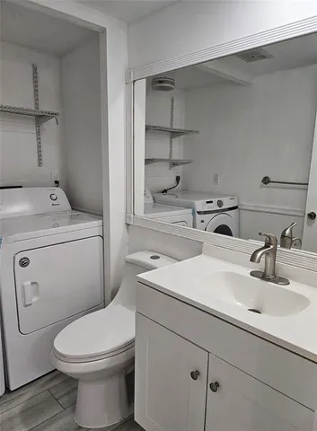 a bathroom with a sink toilet and a mirror