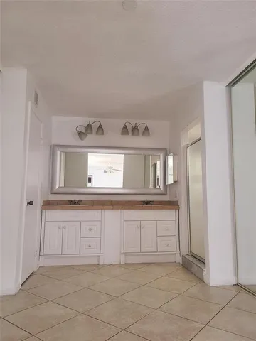a spacious bathroom with a sink and a mirror