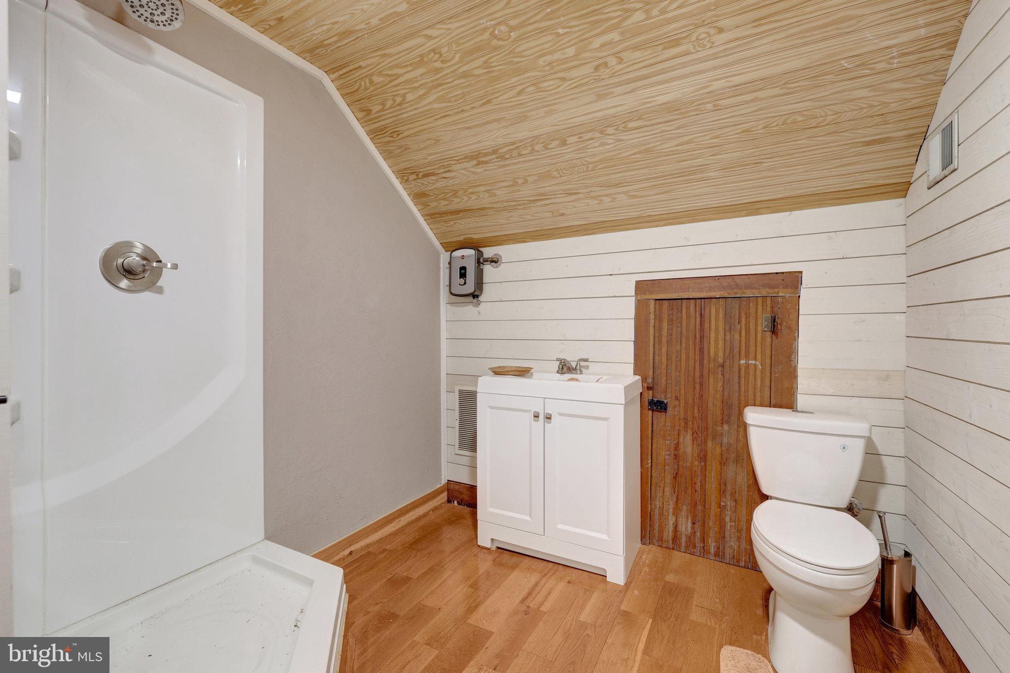 39 New Cut Road Round Hill, VA 20141 - Photo 14 of 33 a bathroom with a toilet a sink and wooden floor