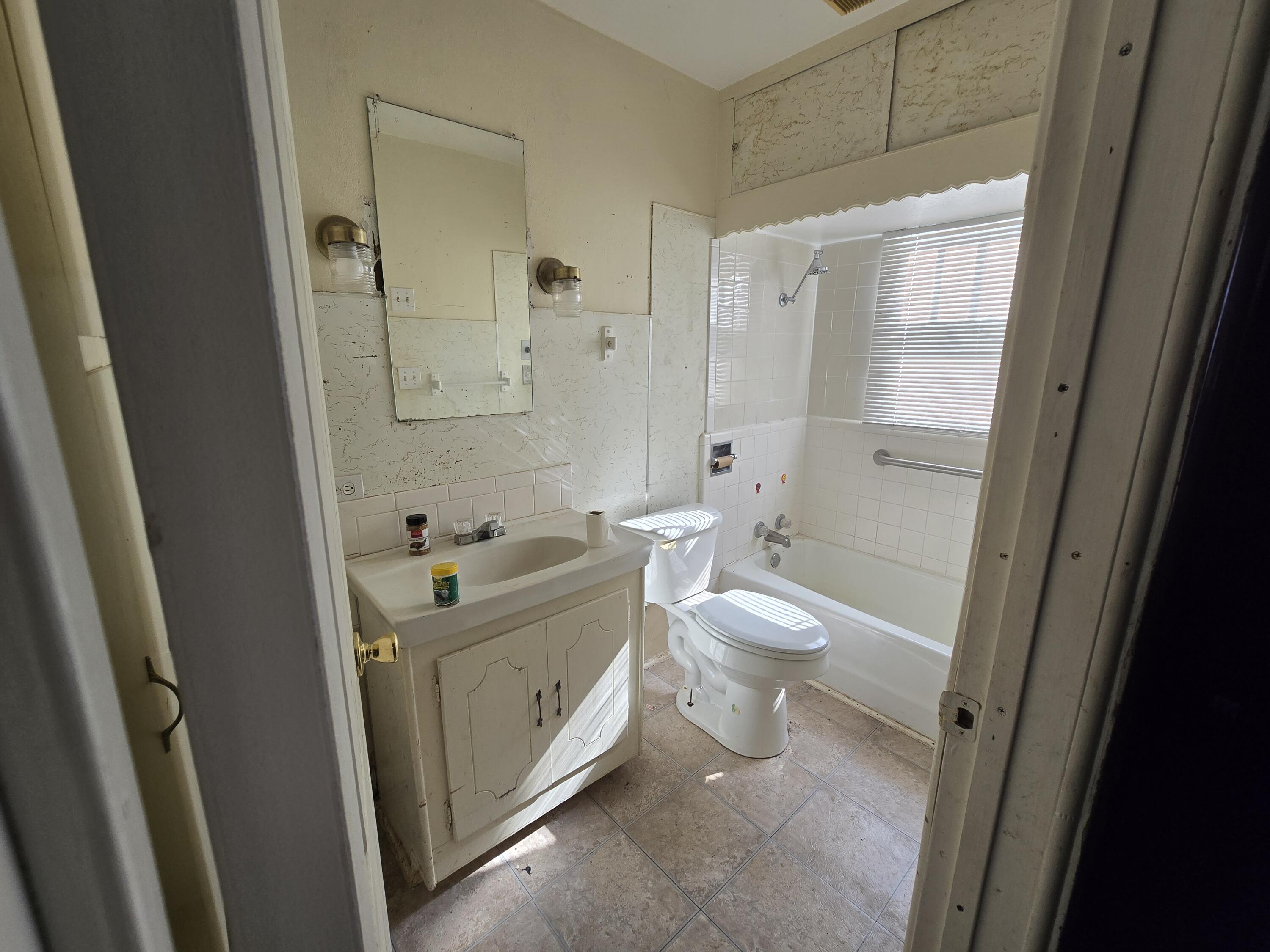 1006 Nassau Plainview, TX 79072 - Photo 5 of 10 a bathroom with a granite countertop toilet a sink and a shower