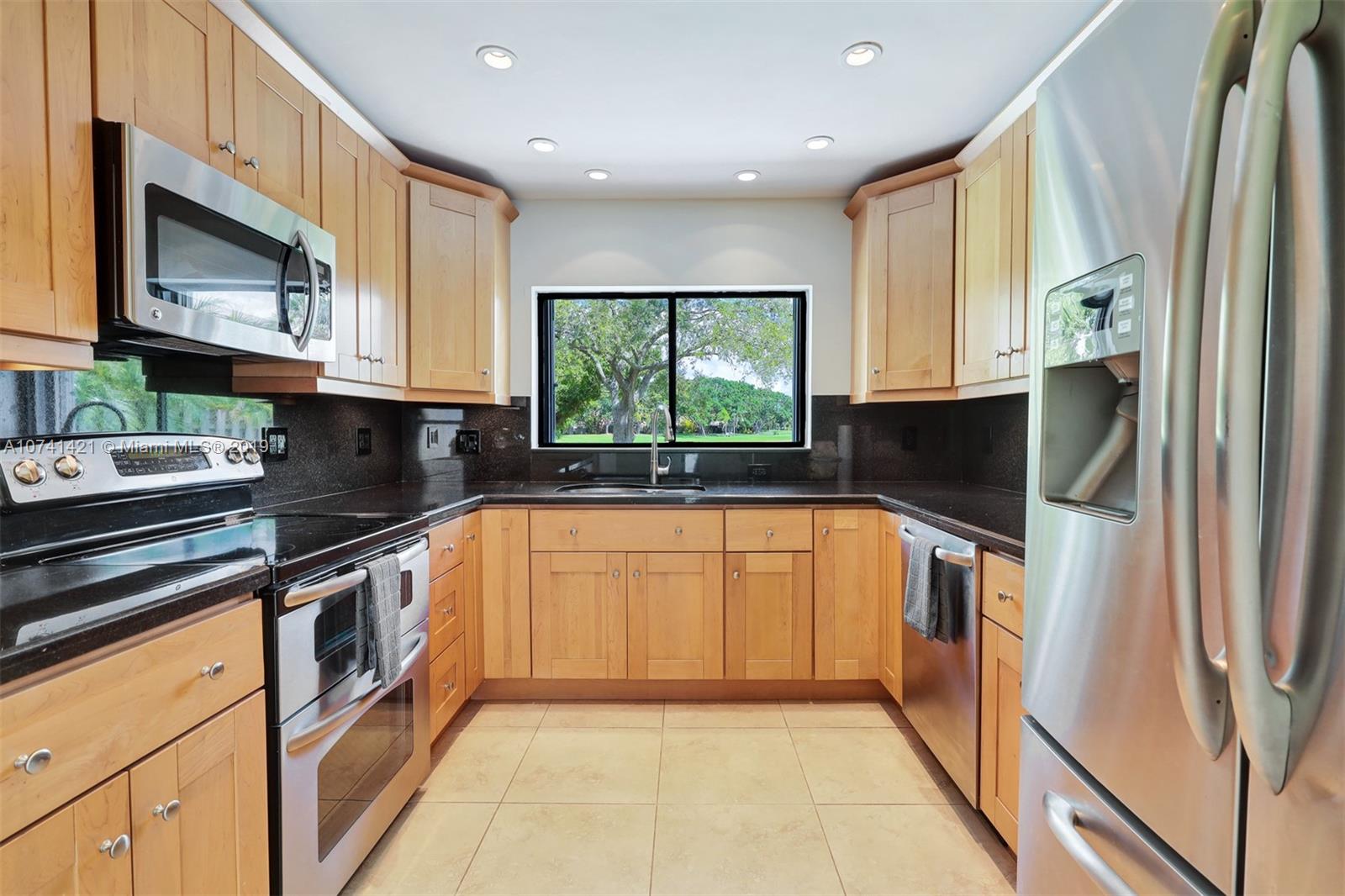 15041 Southwest 96th Terrace Miami, FL 33196 - Photo 7 of 16 a kitchen with stainless steel appliances granite countertop a stove a sink and a microwave