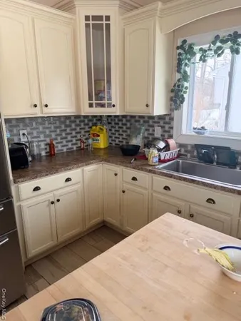 a kitchen with white cabinets a sink and dishwasher