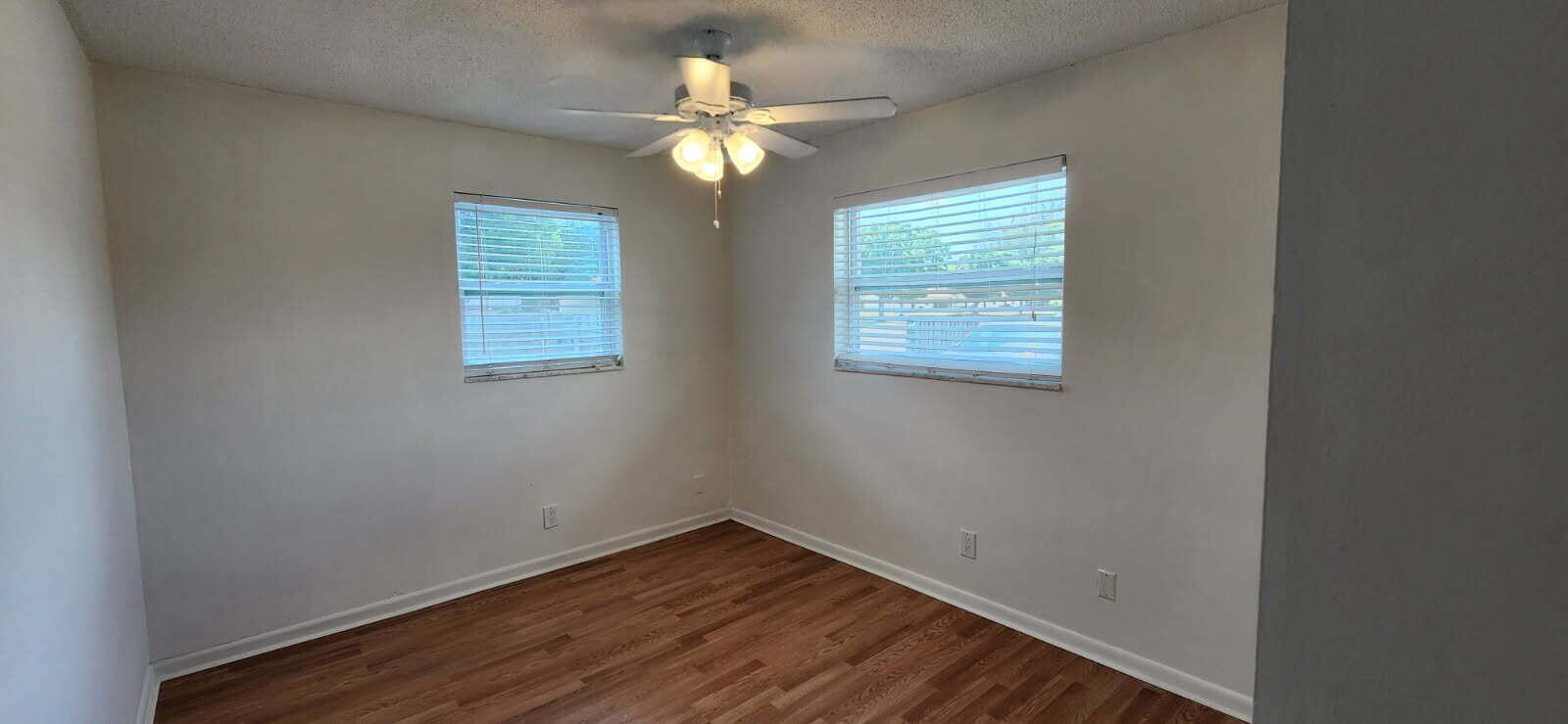 3831 Beacon Hill Road Jupiter, FL 33469 - Photo 7 of 9 an empty room with wooden floor and windows
