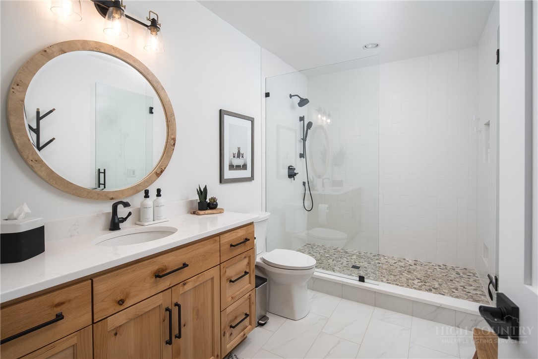 1236 Ninebark Road Boone, NC 28607 - Photo 36 of 50 a bathroom with a granite countertop toilet a sink and a mirror