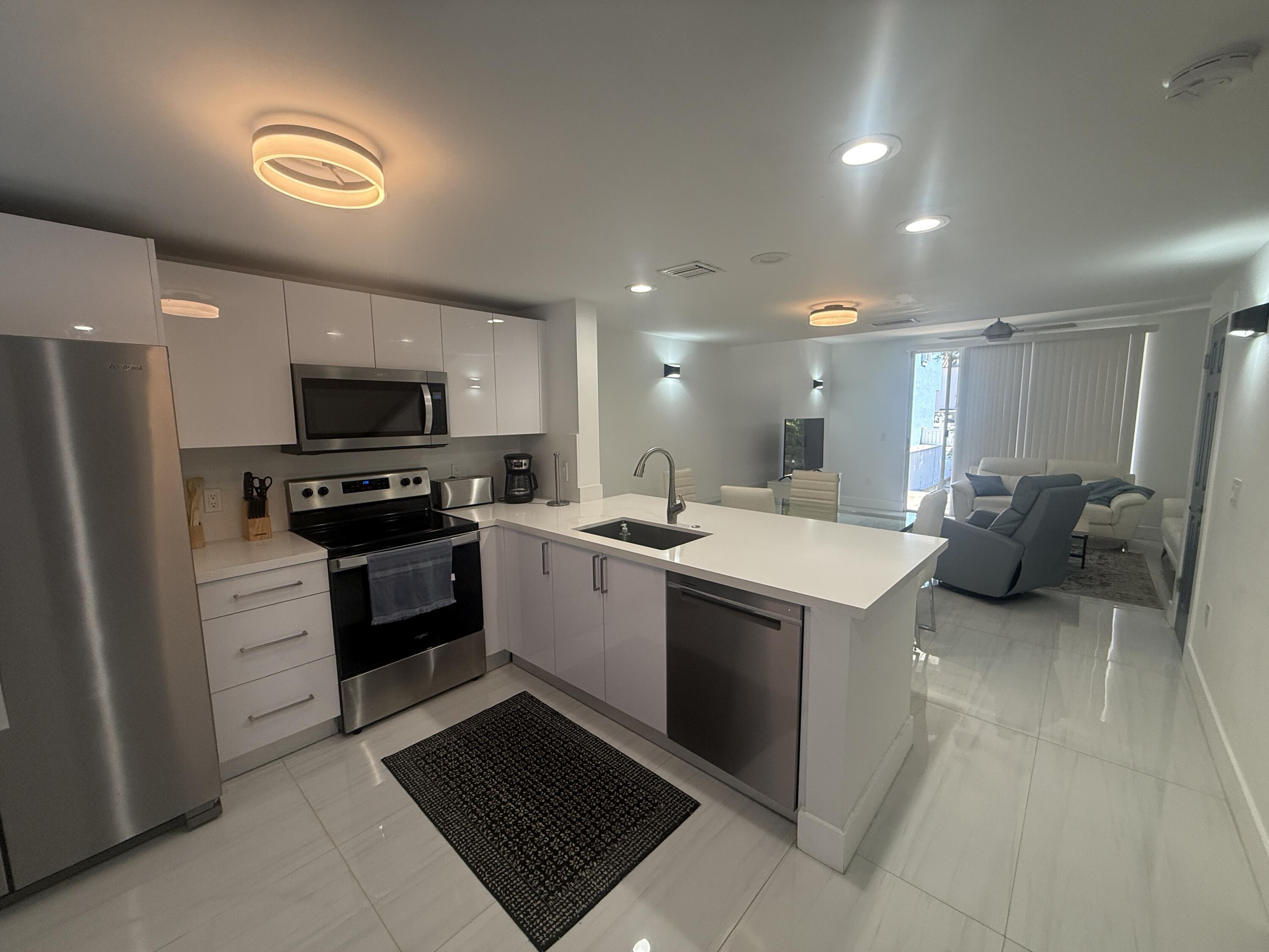 972 Jeffery Street Boca Raton, FL 33487 - Photo 2 of 16 a kitchen with a sink stainless steel appliances and cabinets