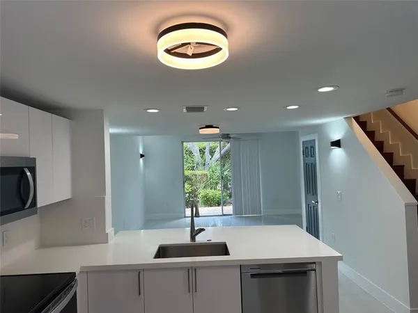 a kitchen with kitchen island a sink stainless steel appliances and cabinets