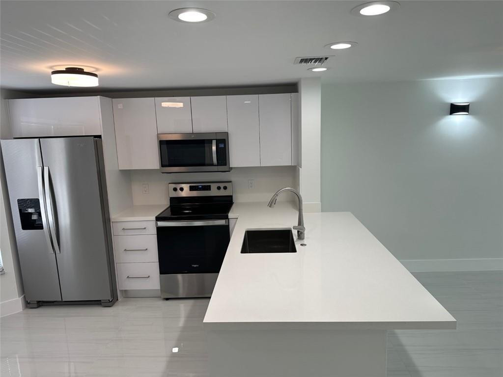 972 Jeffery Street Boca Raton, FL 33487 - Photo 5 of 18 a kitchen with a refrigerator stove and microwave