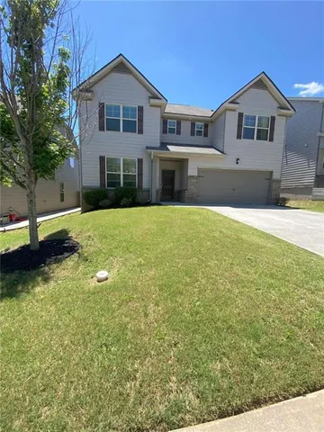 a front view of a house with a yard and garage