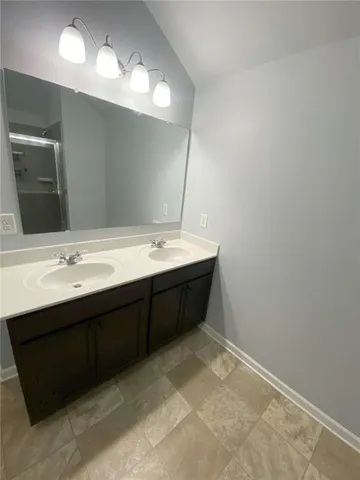 a bathroom with a double vanity sink and a mirror