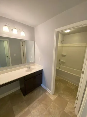 a bathroom with a bathtub sink and mirror