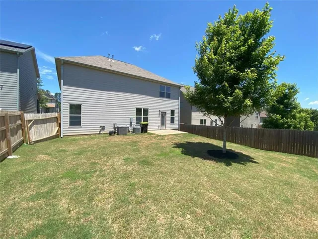 a view of a house with a yard and a tree