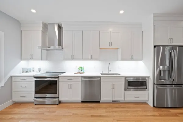 a kitchen with stainless steel appliances granite countertop a stove a sink and a refrigerator