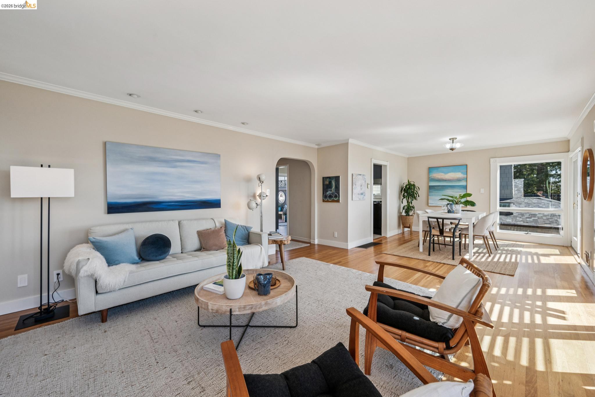 290 Colgate Avenue Kensington, CA 94708 - Photo 14 of 52 Living room featuring arched walkways, light wood-style flooring, and ornamental molding