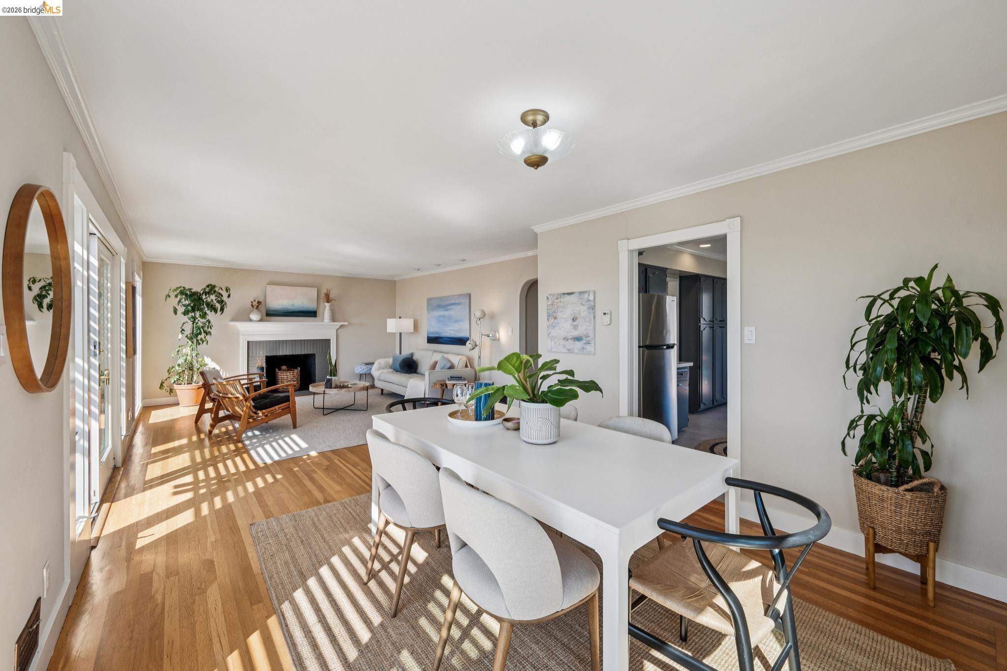 290 Colgate Avenue Kensington, CA 94708 - Photo 19 of 52 Dining room featuring light wood finished floors, crown molding, and a fireplace